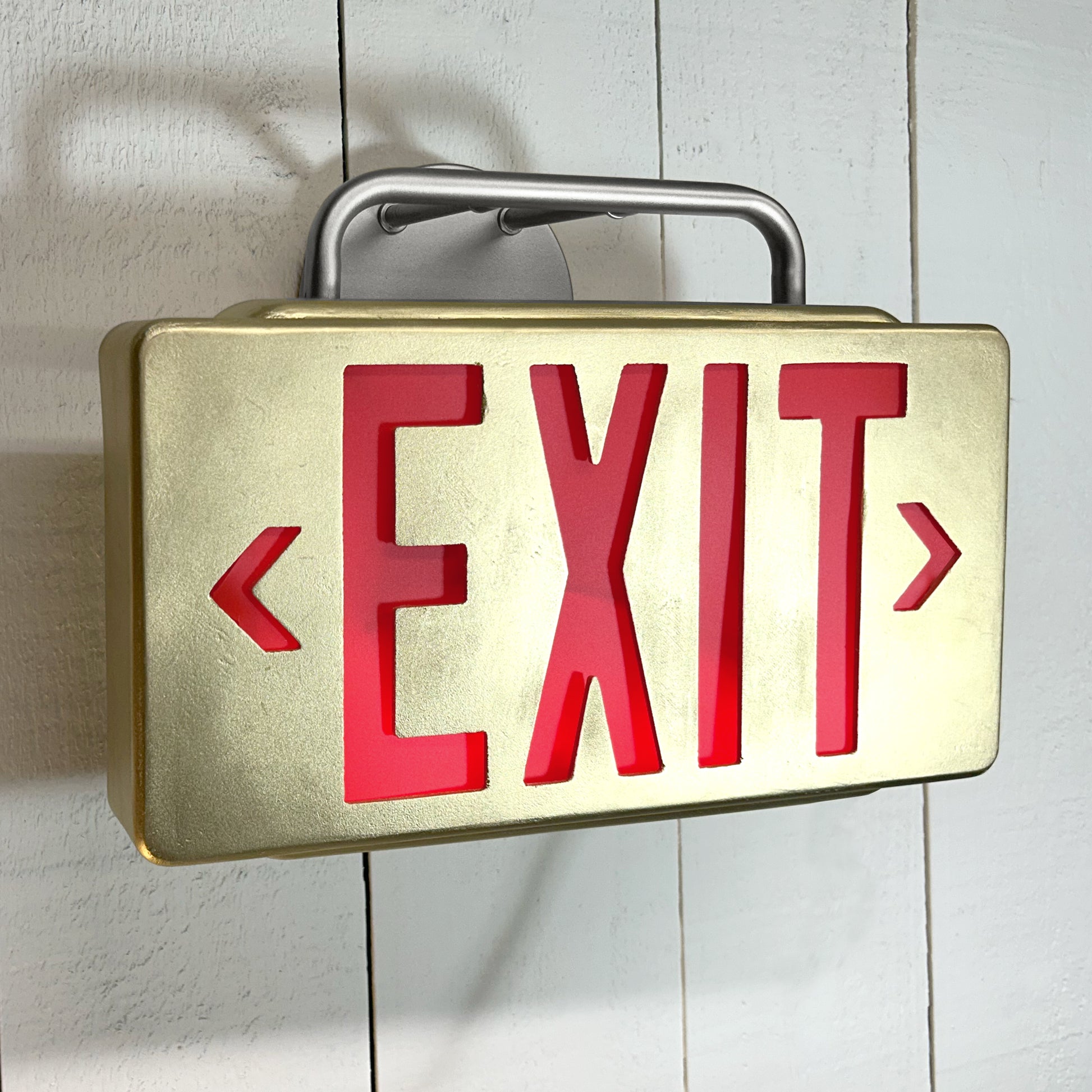 Exit sign with red letters on a white wall
