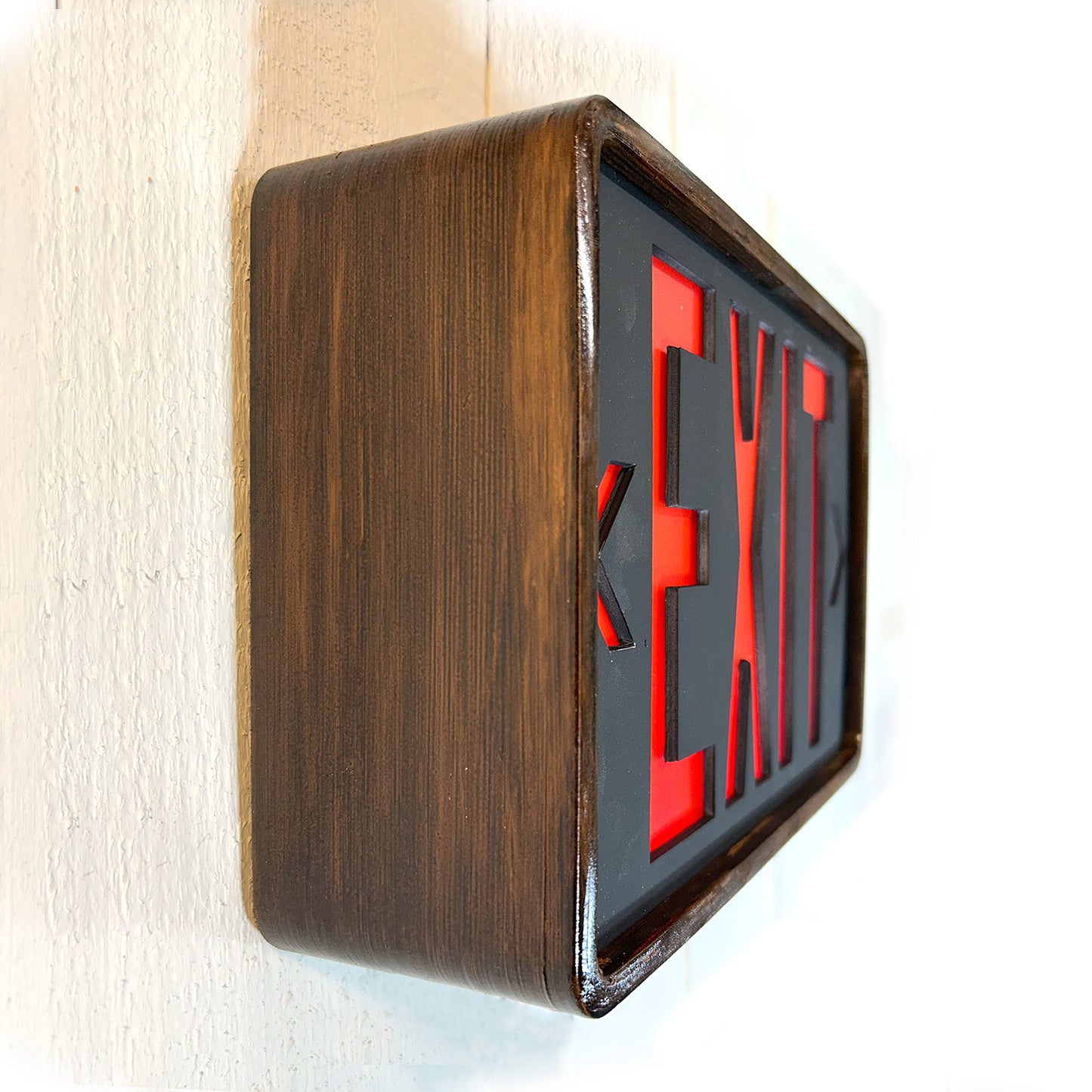 Eames inspired wooden frame with red and black 'EXIT' sign on a white wall