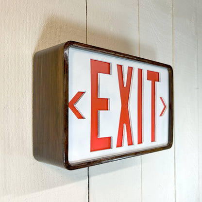 Eames inspired exit sign with red letters on a white background, mounted on a wall.