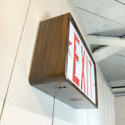 Wooden-framed exit sign on a white wall